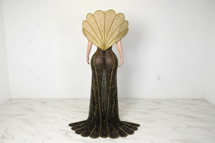 Yembi Fashion gold crystal maxi dress with structured avant-garde fan collar, sheer black nude illusion mesh, and vertical rhinestone linear lines with high slit