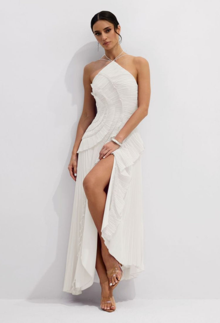 Yembi Fashion luxury white halter pleated maxi gown featuring an asymmetric tiered plisse bodice, halter neck straps, and a dramatic ruffle high slit skirt