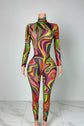 Yembi Fashion luxury multicolor rhinestone jumpsuit featuring a psychedelic abstract wavy swirl pattern of vibrant rainbow crystals on a nude illusion mock neck catsuit