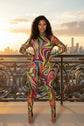 Yembi Fashion luxury multicolor rhinestone jumpsuit featuring a psychedelic abstract wavy swirl pattern of vibrant rainbow crystals on a nude illusion mock neck catsuit
