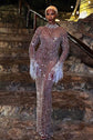 Yembi Fashion nude illusion crystal gown with sheer brown mesh, vertical wavy silver rhinestone patterns, and hanging crystal fringe cuffs