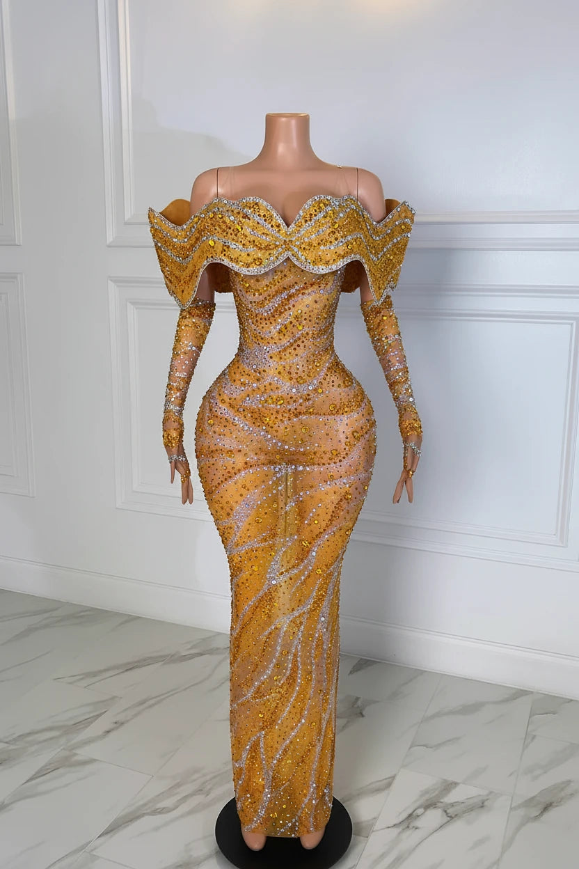 Yembi Fashion gold crystal maxi dress with structured off the shoulder ruffled collar, long sleeves, sheer nude illusion mesh, and wavy silver rhinestone lines