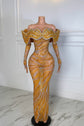Yembi Fashion gold crystal maxi dress with structured off the shoulder ruffled collar, long sleeves, sheer nude illusion mesh, and wavy silver rhinestone lines