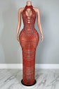 Mannequin wearing a red beaded evening gown in an elegant room setting.