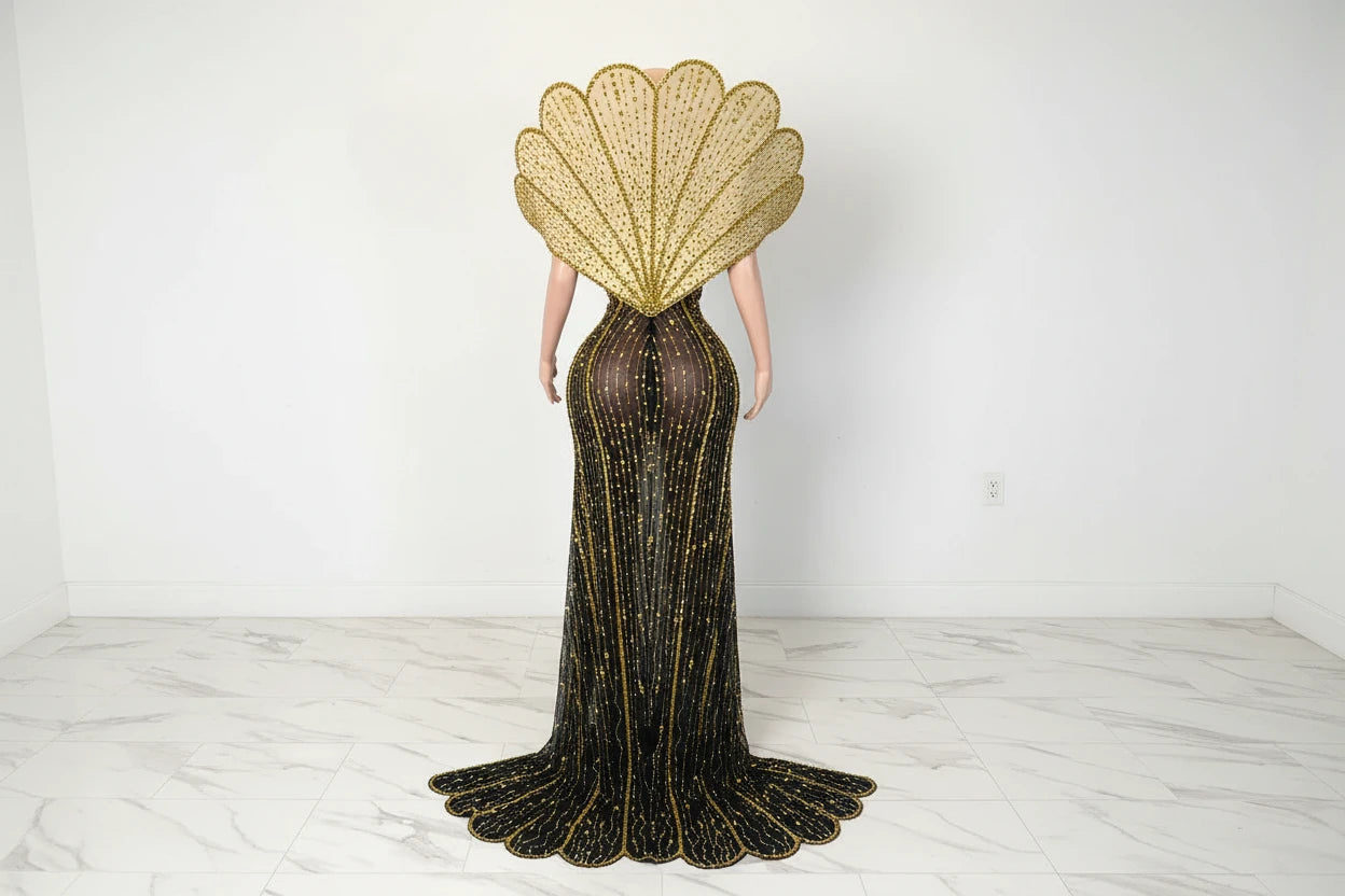 Yembi Fashion gold crystal maxi dress with structured avant-garde fan collar, sheer black nude illusion mesh, and vertical rhinestone linear lines with high slit