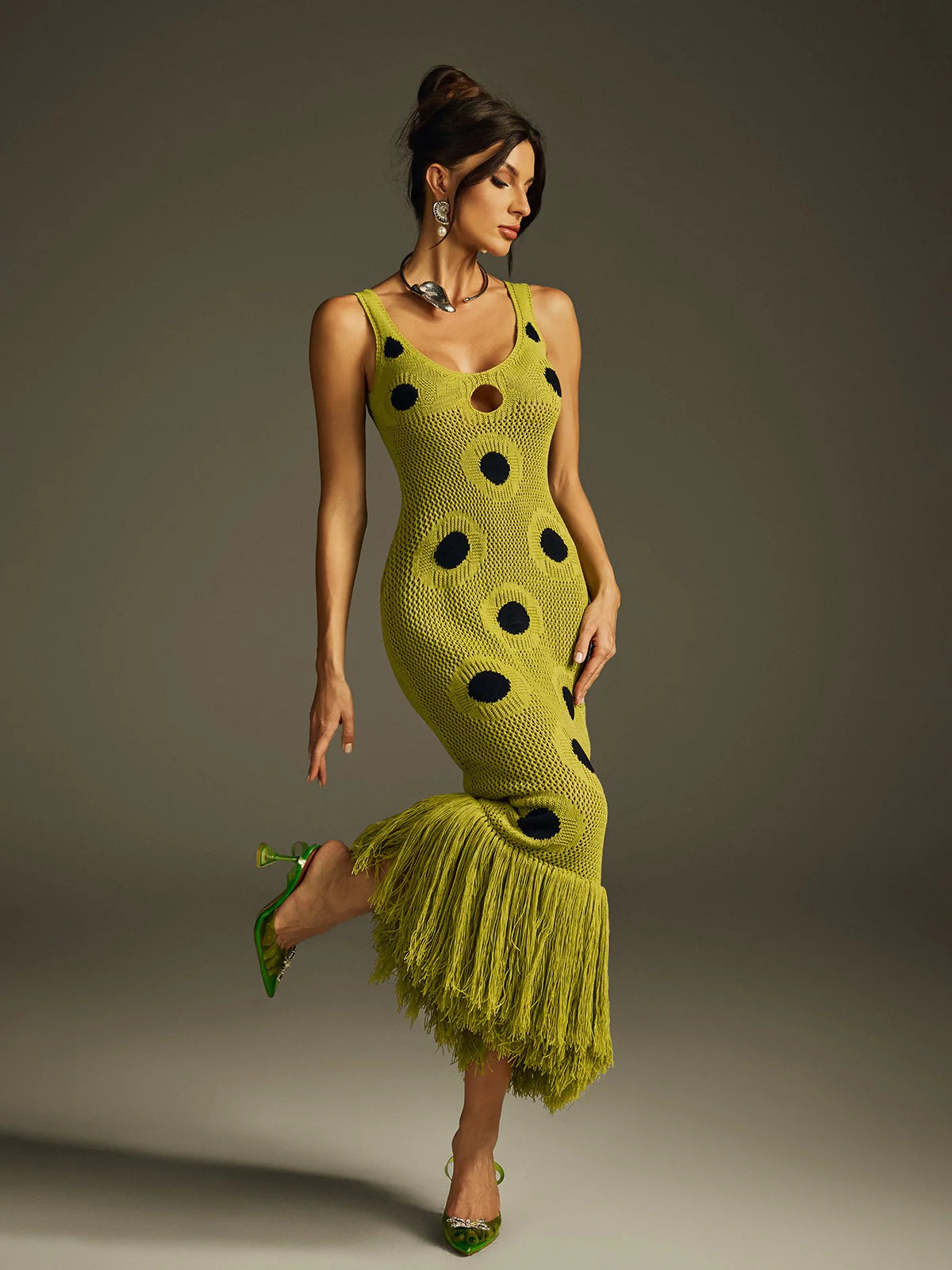 Yembi Fashion luxury olive green polka dot knit maxi dress featuring a chartreuse crochet sleeveless silhouette with black polka dots, center cutout, and a long fringe hem