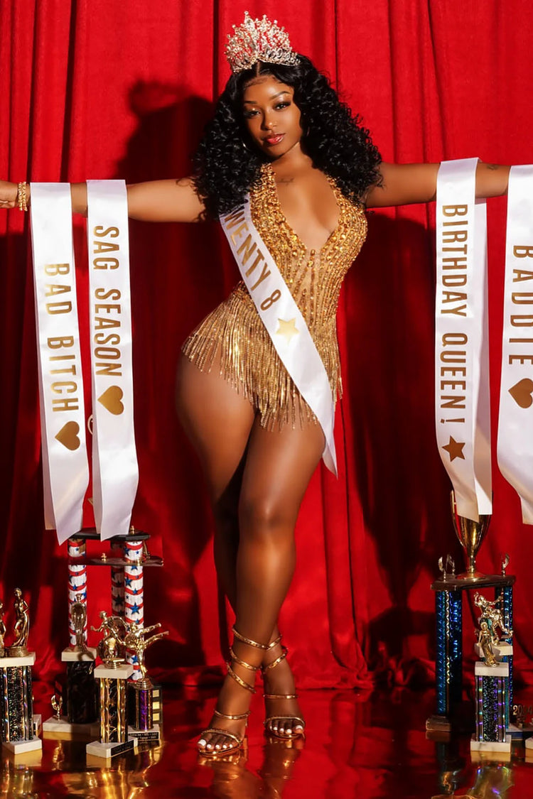 Yembi Fashion luxury gold rhinestone fringe bodysuit featuring a sparkly crystal halter bodice with a plunging deep V-neckline and cascading metallic fringe chains