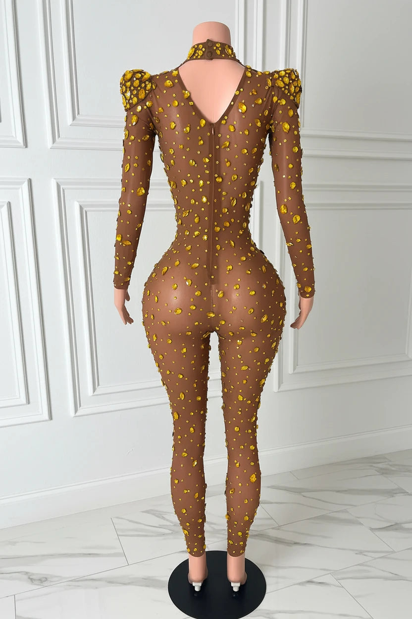 Yembi Fashion gold rhinestone jumpsuit with nude illusion mesh, high mock neck, and structured puff shoulders adorned with yellow crystals