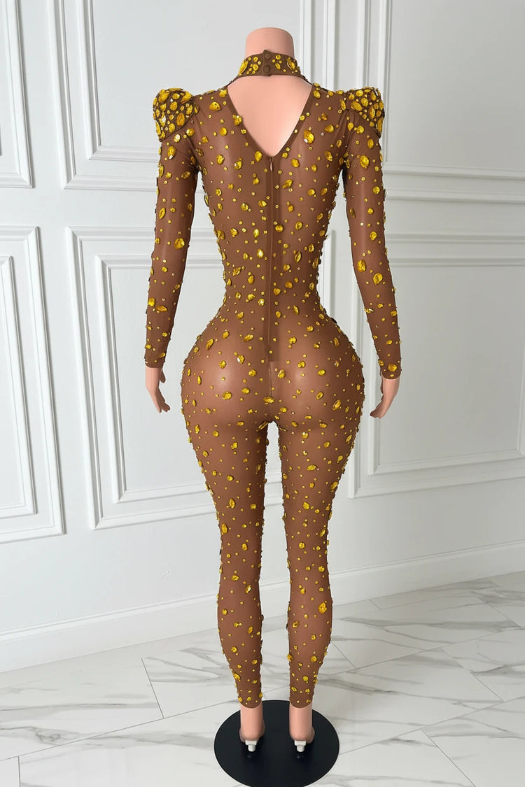Yembi Fashion gold rhinestone jumpsuit with nude illusion mesh, high mock neck, and structured puff shoulders adorned with yellow crystals