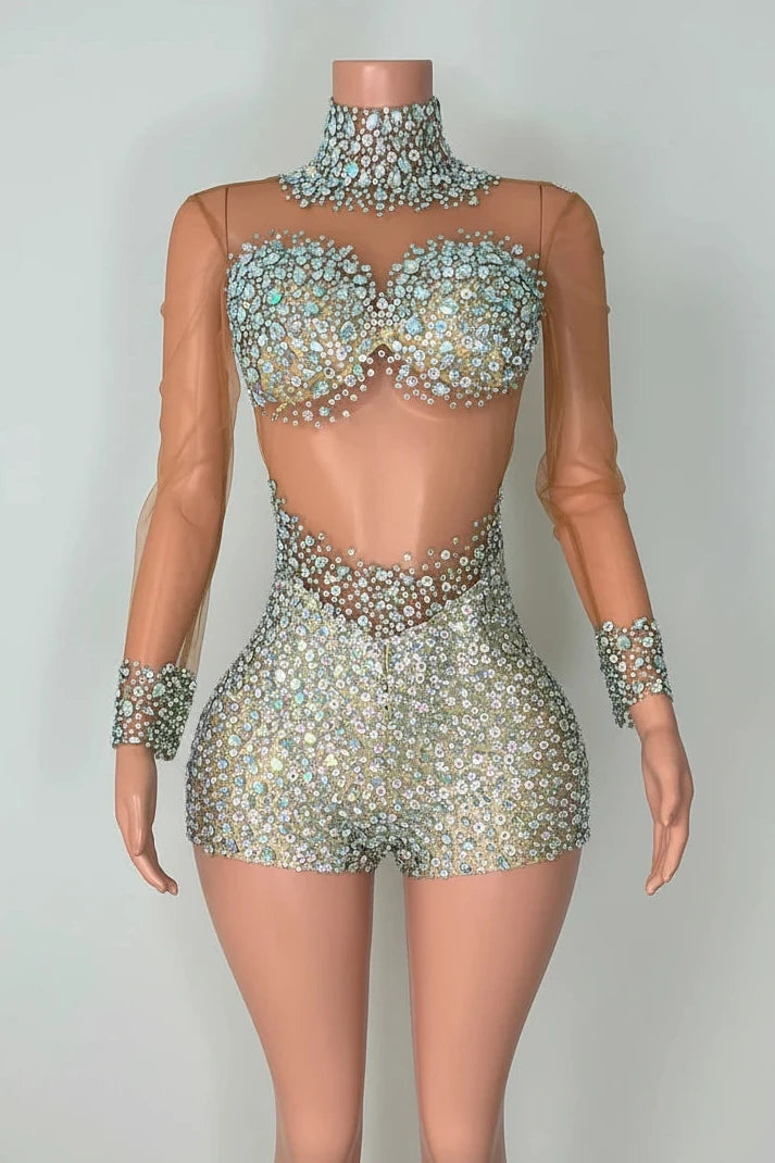 Yembi Fashion luxury silver rhinestone romper featuring a high-density crystal bustier and high-waisted sparkly shorts layout on a nude illusion sheer mesh long sleeve bodysuit