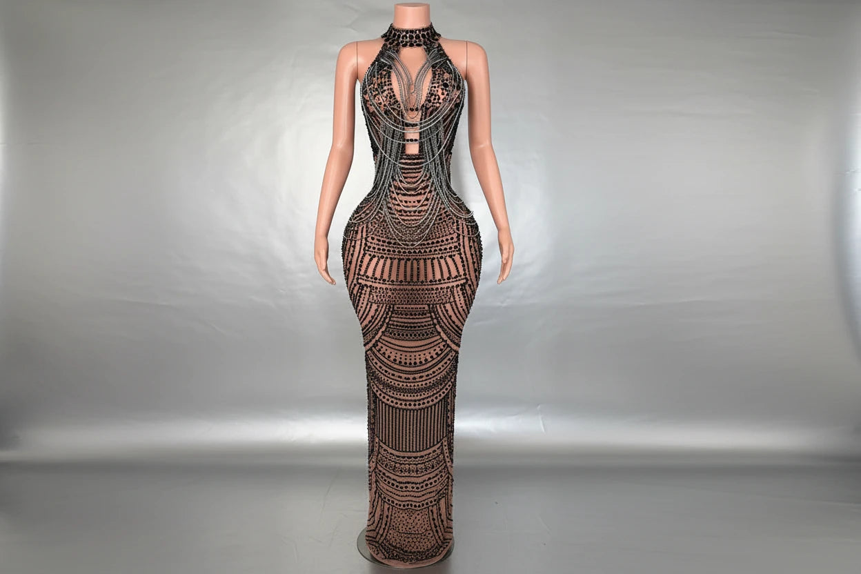 Yembi Fashion black rhinestone maxi dress with nude illusion mesh, embellished halter neck, and layered metallic body chains