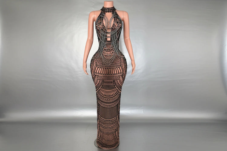 Yembi Fashion black rhinestone maxi dress with nude illusion mesh, embellished halter neck, and layered metallic body chains