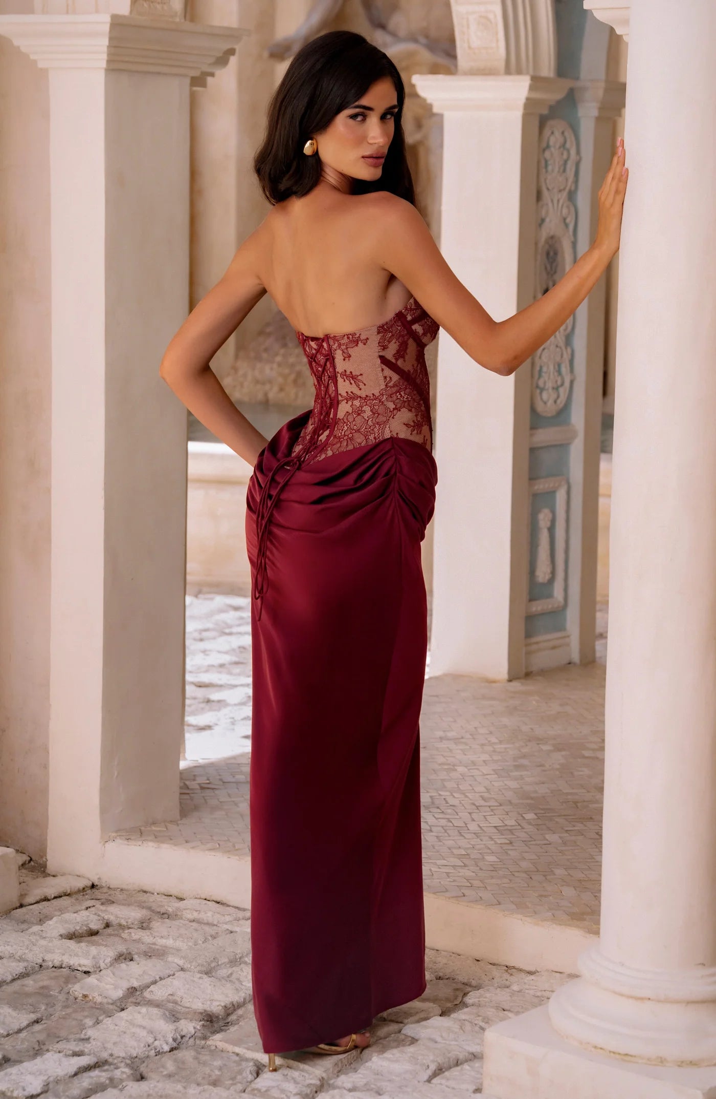 Yembi Fashion luxury red strapless maxi gown featuring a structured corset bodice and a dramatic draped basque waist skirt