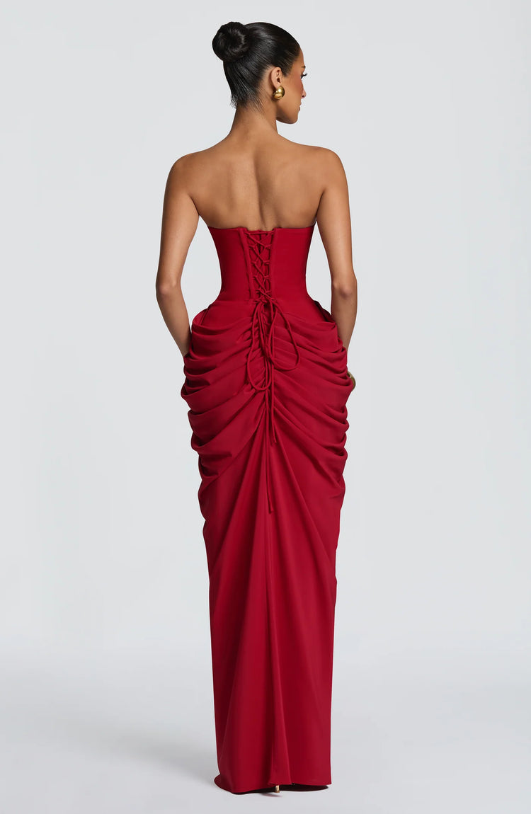 Yembi Fashion luxury red strapless maxi gown featuring a structured corset bodice and a dramatic draped basque waist skirt