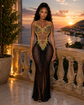 Yembi Fashion gold crystal maxi dress with plunging sweetheart neckline, sheer black nude illusion mesh, midriff cutouts, and amber rhinestone bodice embroidery
