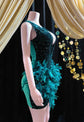 Dark green feather-embellished mini dress with rhinestone details, perfect for a birthday celebration or special event.
