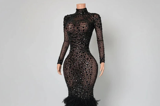 Black lace evening gown with Yembi Fashion emerald green sequin prom dress with strapless sweetheart neckline, sheer mesh thigh panel, and formal mermaid train
 skirt on a mannequin against a white wall.