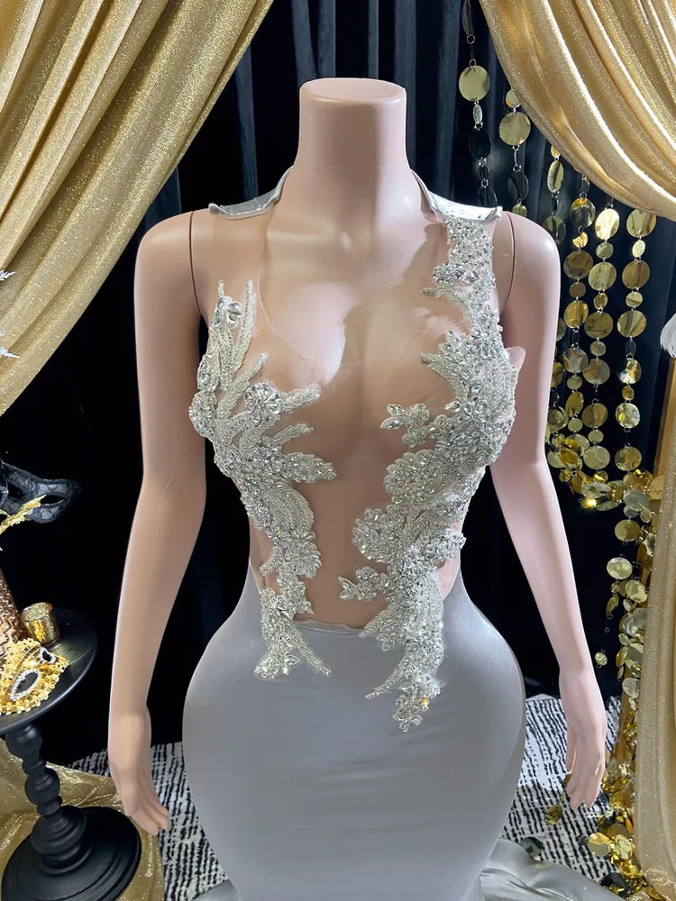 Yembi Fashion silver rhinestone mermaid gown with sheer nude illusion mesh bodice, silver crystal baroque embroidery, and fluid liquid satin train skirt