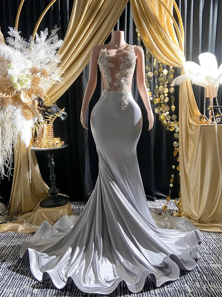 Yembi Fashion silver rhinestone mermaid gown with sheer nude illusion mesh bodice, silver crystal baroque embroidery, and fluid liquid satin train skirt