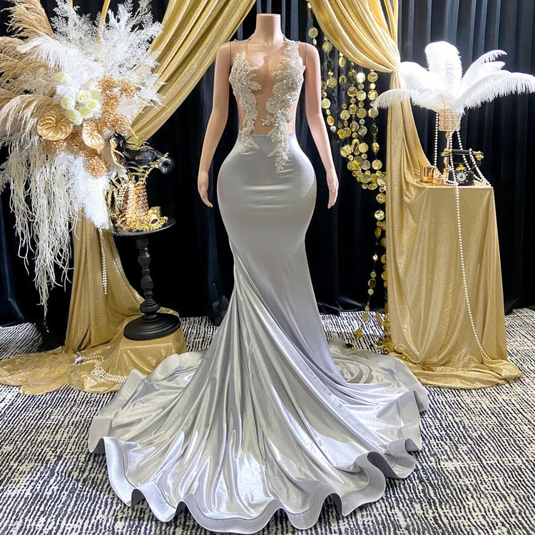 Yembi Fashion silver rhinestone mermaid gown with sheer nude illusion mesh bodice, silver crystal baroque embroidery, and fluid liquid satin train skirt