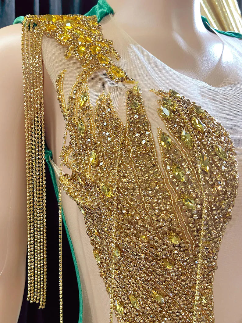 Yembi Fashion green velvet mermaid gown with gold crystal embellished bodice, shoulder fringe tassels, sheer nude illusion hip cutouts, and emerald velour train