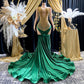 Yembi Fashion green velvet mermaid gown with gold crystal embellished bodice, shoulder fringe tassels, sheer nude illusion hip cutouts, and emerald velour train