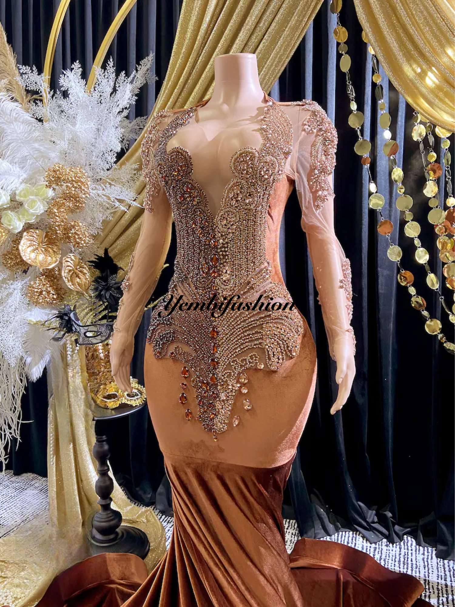 Yembi Fashion brown velvet mermaid gown with high neck, long sheer mesh sleeves, heavy bronze crystal baroque embroidery, and rich chocolate velour train