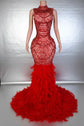 Yembi Fashion red feather crystal gown with high mock neck, nude illusion mesh bodice with ruby pearl beadwork, and plush ostrich feather mermaid train