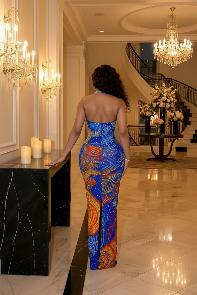 Yembi Fashion multicolor crystal maxi dress with halter neckline, sheer nude illusion mesh, and abstract swirling patterns of royal blue and orange rhinestones