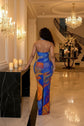 Yembi Fashion multicolor crystal maxi dress with halter neckline, sheer nude illusion mesh, and abstract swirling patterns of royal blue and orange rhinestones